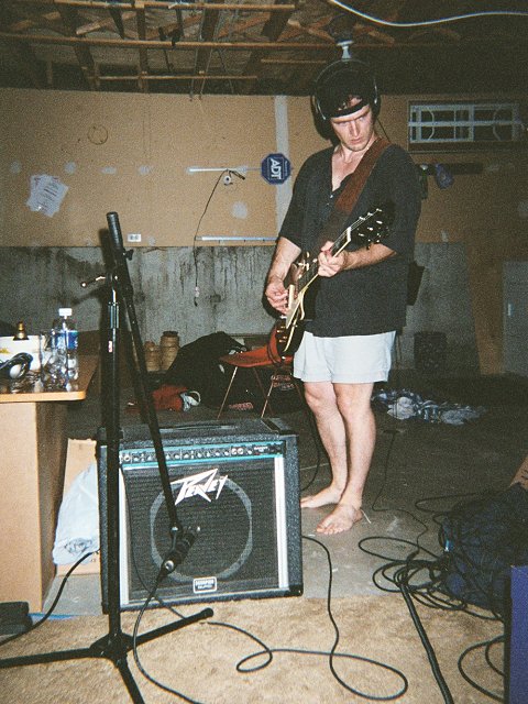 A picture of Troy Jones recording a guitar track