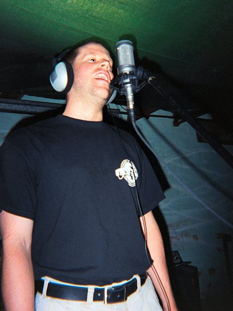 A picture of Stephan Meyer singing into the microphone as he records a vocal track